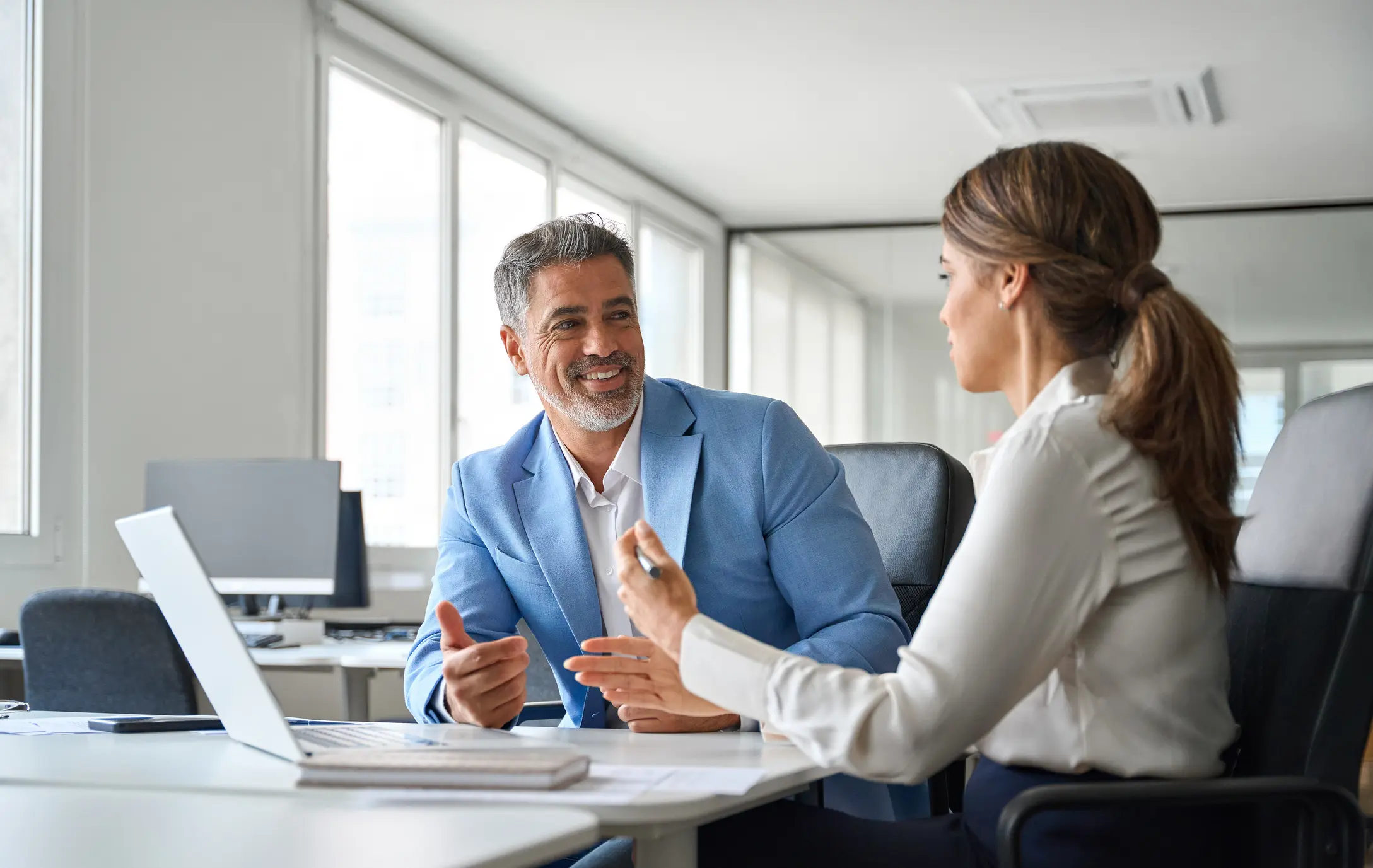Two people talking at a desk